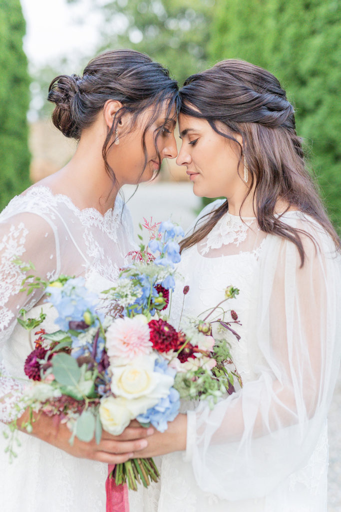 LGBTQ+ destination wedding inspiration.
Lesbian wedding couple holding a gorgeous lush summer wedding bouquet with red, blue, and blush flowers. Flowers in the bouquet are dahlia's, hydrangea, delphinium, and roses.
Image by Lukas und Sophia
#lovelyandplanned
