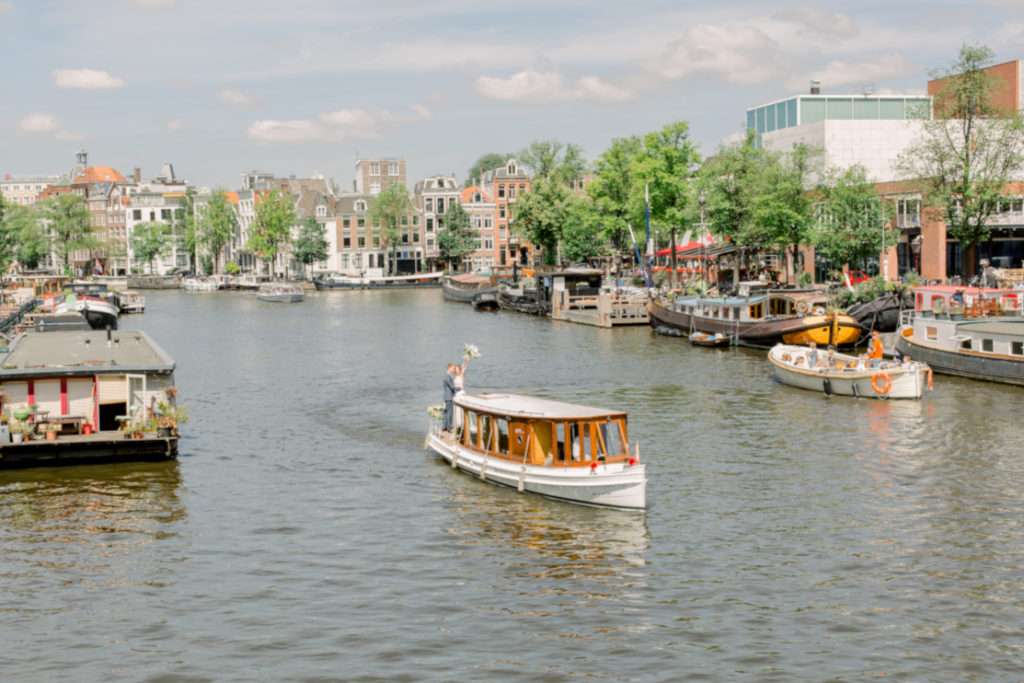 Destination Wedding in Amsterdam:
wedding couple standing on a boat cruising along the Amsterdam waterways (grachts). The boat is a beautifully restored saloon boat from Smidtje Luxury Cruises.
Image by Nancy Twickler Photography
#lovelyandplanned

